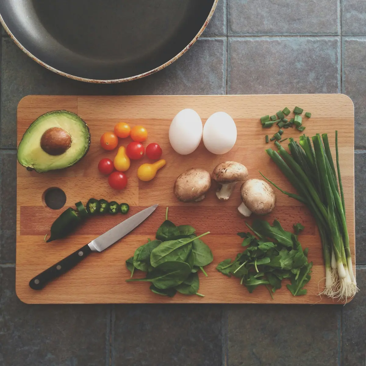Tavola di legno con verdure fresche e un pasto completo